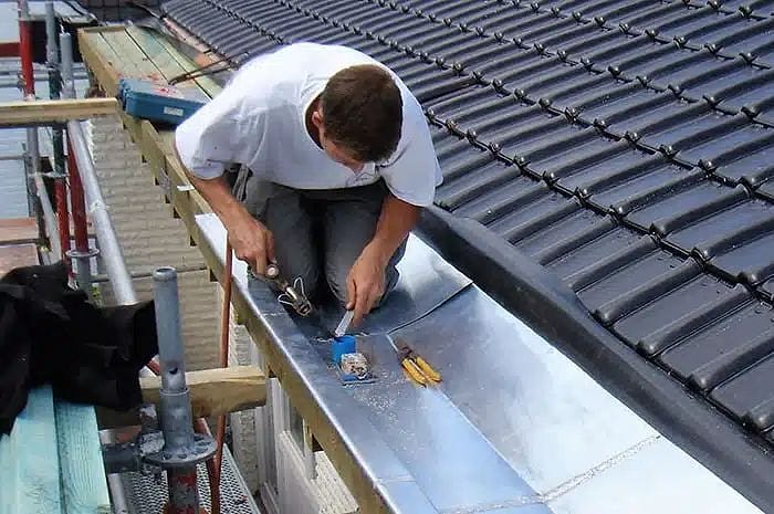 Couvreur zingueur soudant un ouvrage en zinc sur une toiture